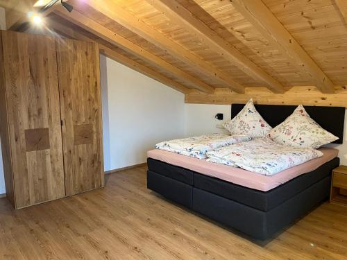 ビショフスヴィーゼンにあるFerienwohnung Hirnsberglehenの木製の天井が特徴のベッドルーム1室(ベッド1台付)