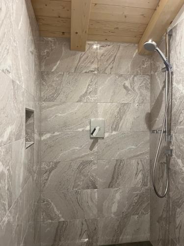 a bathroom with a shower with a stone wall at Ferienwohnung Hirnsberglehen in Bischofswiesen
