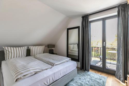a bedroom with a bed and a large window at Horst Wai Hues in Westerland (Sylt)