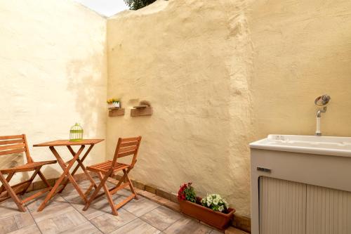 a patio with a table and chairs and a sink at Appartamento Libio Porto Torres in Porto Torres