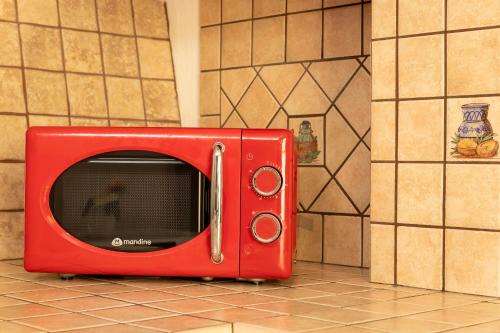 a red microwave sitting on top of a floor at Appartamento Libio Porto Torres in Porto Torres