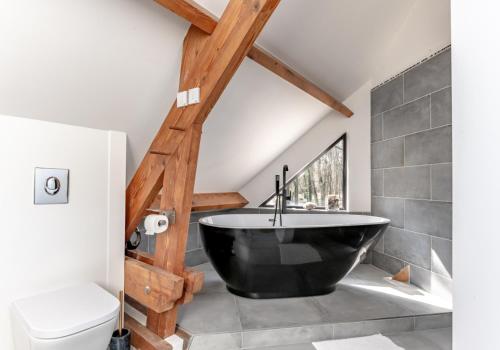 a bathroom with a black bath tub in the attic at Villa d'architecte avec Piscine proche Paris in Rochefort-en-Yvelines