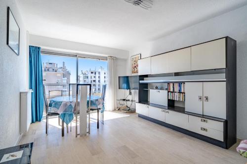 une salle à manger avec une table et une vue sur la ville dans l'établissement Apt Golfe-Juan à 150 m de la plage et près de Cannes , Centre et Gare, à Vallauris