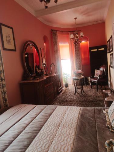 a bedroom with a large bed and a mirror at Real Santo António Guest House in Tarouca