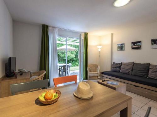 - un salon avec un canapé et une table dans l'établissement Holiday home Club Le Domaine Du Golf 2, à Saint-Hilaire-Saint-Florent