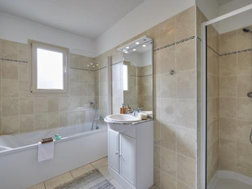 ein Badezimmer mit Waschbecken, Badewanne und Dusche in der Unterkunft Villa in France with Private Garden in Lanzac