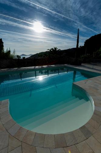 a swimming pool at night with the sun setting at Borgo dell'Uccellaia - Smeraldo in Marciana Marina