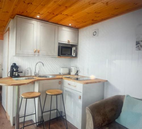 The school lodge في Burwarton: مطبخ مع حوض ومكتب مع الكراسي