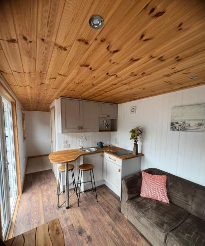 The school lodge في Burwarton: مطبخ مع أريكة وطاولة في منزل صغير