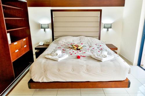 a bedroom with a bed with towels and flowers on it at Galini Eden in Agia Marina Nea Kydonias