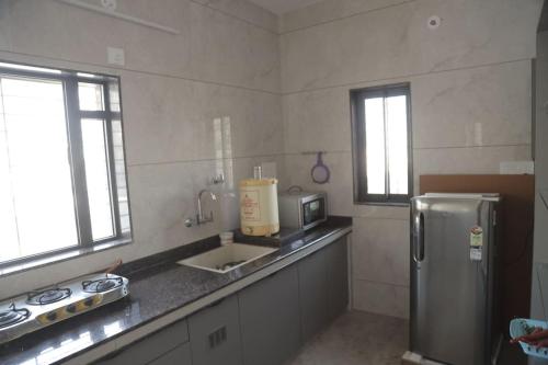 uma cozinha com um lavatório e um frigorífico em Gulmohar Homes em Udaipur