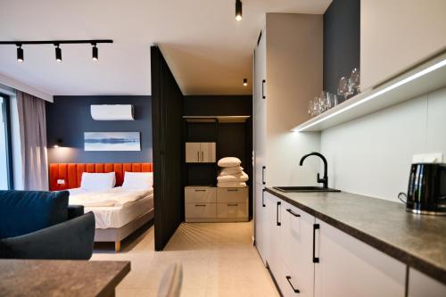 una cocina y un dormitorio con una cama en una habitación en Aparthotel Laguna Beskidów, en Zarzecze