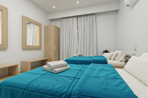 two beds in a room with blue sheets at Caretta Paradise Resort & WaterPark in Tragaki