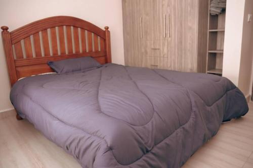 ein Bett mit einer lila Bettdecke in einem Schlafzimmer in der Unterkunft Charming Waterside Escape in Entebbe