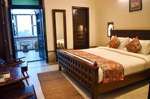 a bedroom with a large bed in a room at Ganga Heritage - By The Palm Bliss Resort in Haridwār