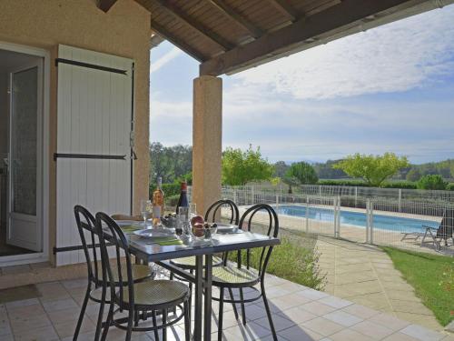- une table et des chaises sur une terrasse avec piscine dans l'établissement Luxury Villa with Private Pool in Saint Victor de Malcap, à Saint-Victor-de-Malcap