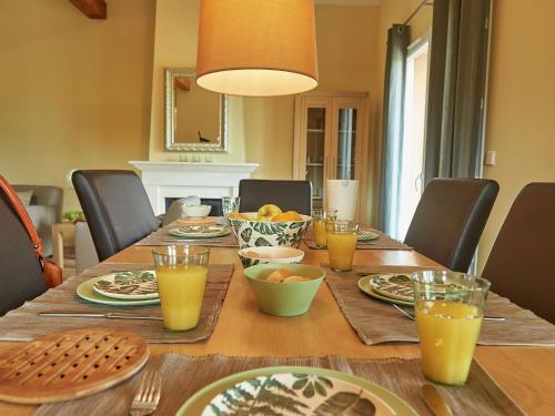 a table with plates and glasses of orange juice on it at Luxe villa in Les Forges with BBQ Garden in Les Forges