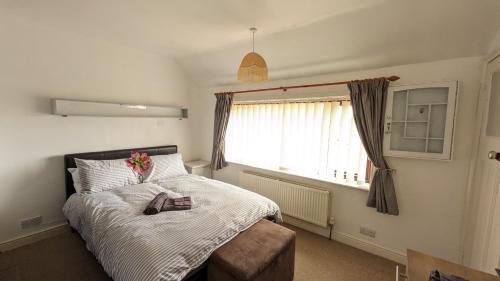 ein Schlafzimmer mit einem Bett mit einer Blume darauf in der Unterkunft Relaxing 3 Bedroom Norwich Haven in Norwich