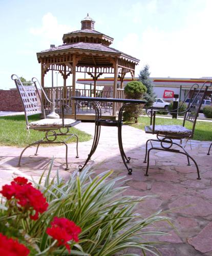 a gazebo in a park with two chairs and flowers at Country Hearth Inn & Suites Edwardsville in Edwardsville