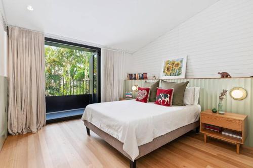 a bedroom with a large bed and a large window at Cozy 3 Bedroom House Annandale in Sydney
