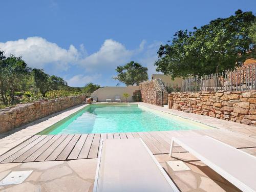 - une piscine à côté d'un mur en pierre dans l'établissement Classy Apartment in Villes que des Corbi res with Swimming Pool, à Villesèque-des-Corbières