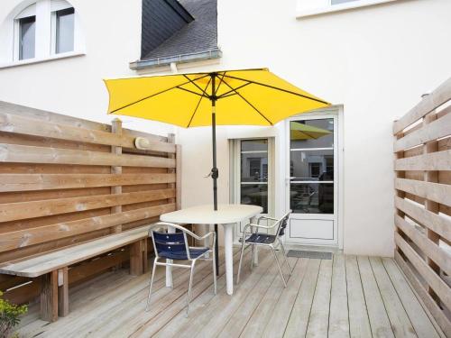 una mesa con una sombrilla amarilla en una terraza de madera en Holiday resort Golfe du Morbihan Larmor Baden acc for 4 pers, en Larmor-Baden