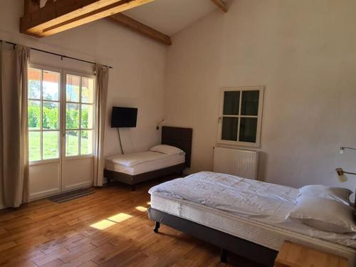 1 dormitorio con 2 camas y TV. en Luxury villa near the cute towns of Sarlat and Rocamadour en Lanzac