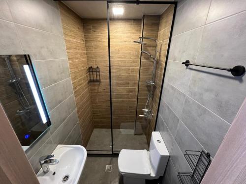 een badkamer met een douche, een toilet en een wastafel bij HOTEL PARIS in Batoemi