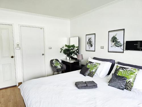 a white bedroom with a large white bed with pillows at Patong Tower Apartment in Patong Beach