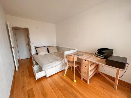 een kamer met een bureau en een bed met een bureau sidx sidx sidx bij Appartement tout confort avec vue in Saint-Denis
