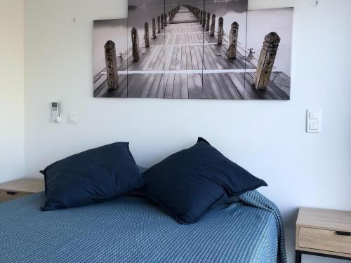 a bedroom with a bed and a picture of a pier at Les Jardins d Eve Solenzara townhouse with private pool in Favone