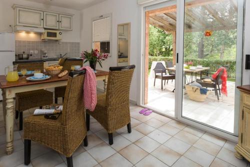 - une cuisine et une salle à manger avec une table et des chaises dans l'établissement Res Mare e Monte Solenzara Bungalow with terrace, à Favone