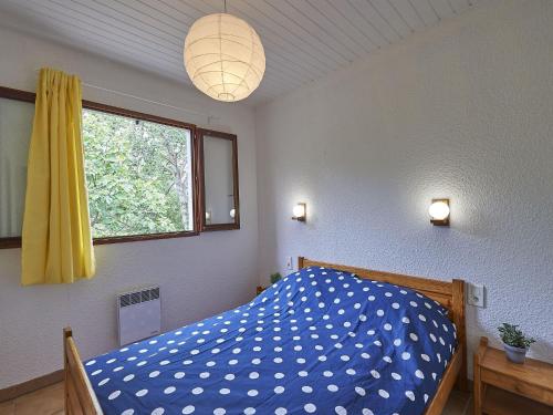 een slaapkamer met een blauw bed en een raam bij Vayamundo L'Espinet in Quillan