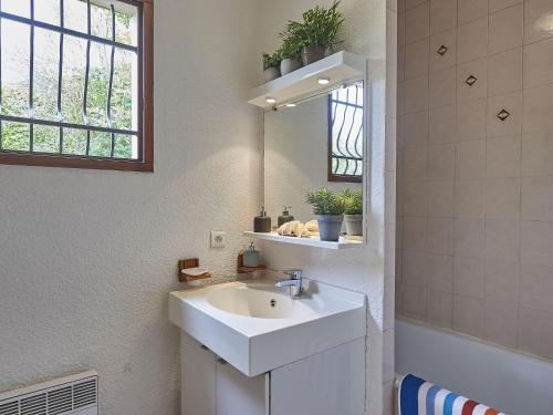 een badkamer met een witte wastafel en een spiegel bij Vayamundo L'Espinet in Quillan