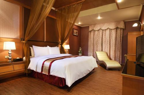 a hotel room with a bed and a television at Natoli Motel in Tainan