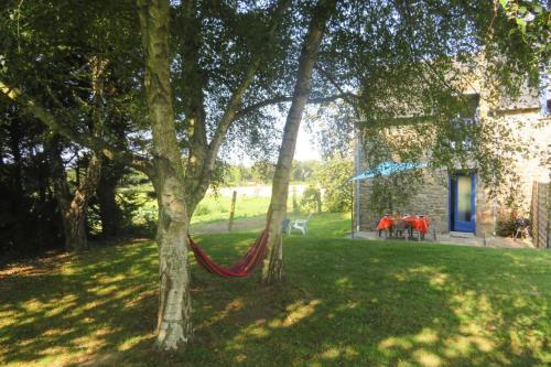 a hammock in a yard next to a house at Terraced house St Meloir des Ondes in Le Bouillon