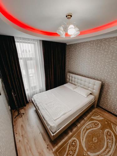 a bedroom with a white bed with a red stripe on the ceiling at Гостевой дом Рамазан-отель in Taraz