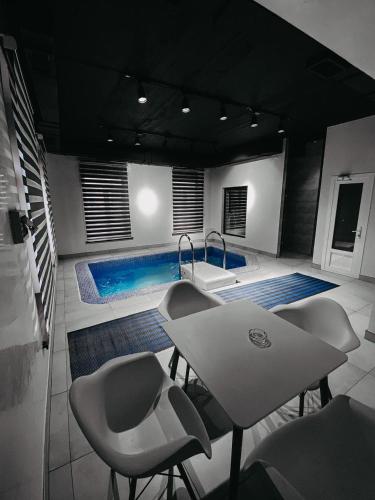 una piscina con mesa y sillas en una habitación en Гостевой дом Рамазан-отель, en Taraz