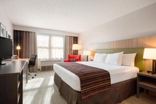 Habitación de hotel con cama grande y escritorio. en Country Inn & Suites by Radisson, Minneapolis West, MN, en Plymouth