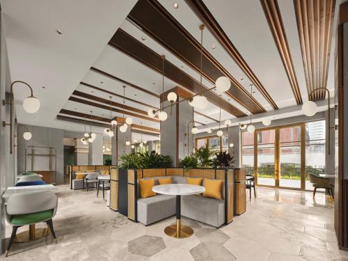 a lobby with tables and chairs and windows at Hilton Garden Inn Hangzhou West Lake in Hangzhou