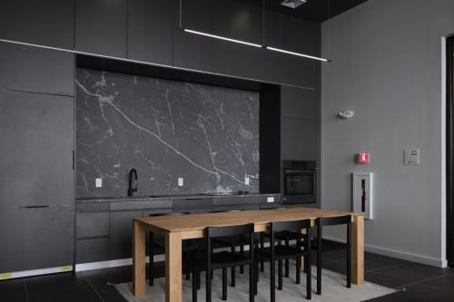 a kitchen with a wooden table and black cabinets at Blueground South Boston gym near T shops BOS-1024 in Boston