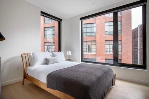 a bedroom with a bed and a large window at Blueground South Boston gym wd nr red line BOS-1023 in Boston