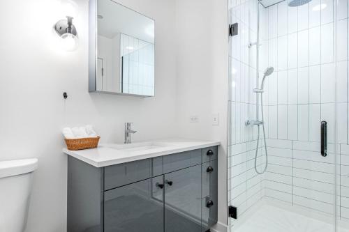 a white bathroom with a sink and a shower at Uptown 1BR w Gym Rooftop Pool 2 blocks to L CHI-383 in Chicago