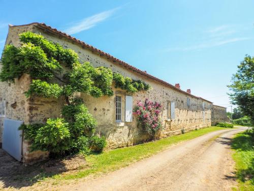 a stone building with plants on it on a dirt road at Holiday Home in Saint Laurent de la Salle with Pool in La Chapelle-Thémer