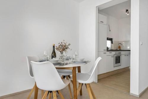 a dining room with a table and white chairs at Casa Bergblick in Bickenbach
