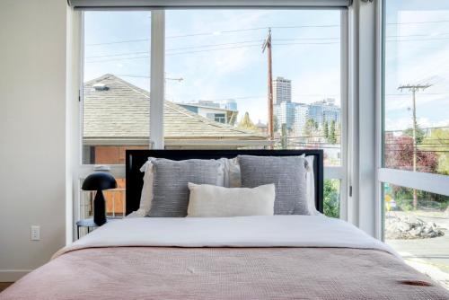 1 dormitorio con cama y ventana grande en Blueground Capitol Hill patio walkable area SEA-726 en Seattle