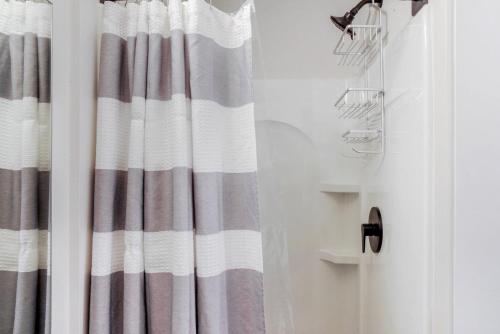 baño con cortina de ducha a rayas y lavamanos en Blueground Capitol Hill patio walkable area SEA-726 en Seattle