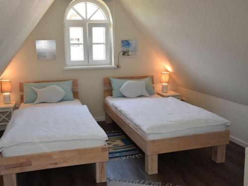 two twin beds in a room with a window at Holiday home Wiedblick in Neu Gaarz
