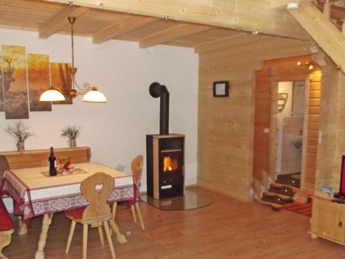 een woonkamer met een tafel en een houtkachel bij Holiday home our little hunting lodge in Philippsreut