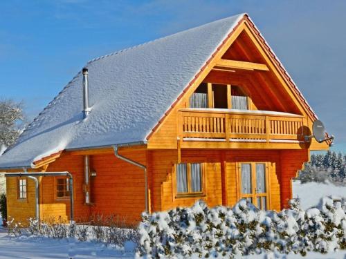 a wooden house with snow on the roof at Holiday home our little hunting lodge in Philippsreut